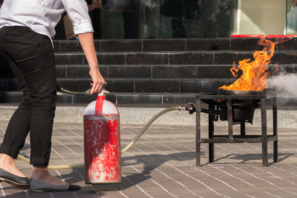Training,A,Woman,To,Use,Fire,Extinguisher.